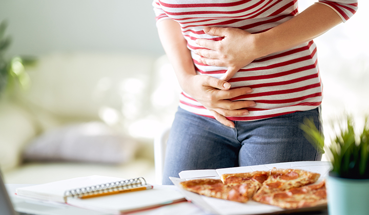 Frau mit Bauchschmerzen nach dem Essen