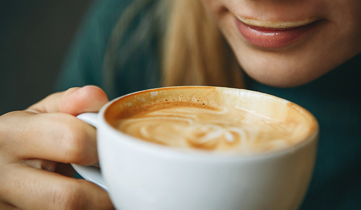 Frau genießt Milchkaffee